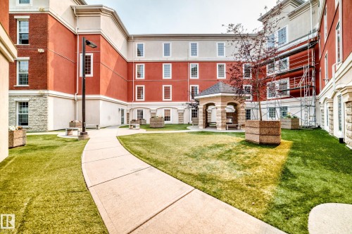 Central courtyard with manicured turf and concrete pathways - #307 1003 Gault Bv Nw, Edmonton, AB - Outdoor With Facade