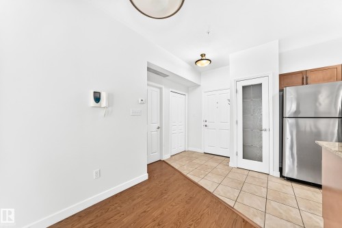 Entryway with a tiled floor and wood-finish flooring - #307 1003 Gault Bv Nw, Edmonton, AB - Indoor