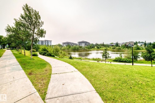 Paved pathways bordered by manicured green spaces and mature trees - #307 1003 Gault Bv Nw, Edmonton, AB - Outdoor With View
