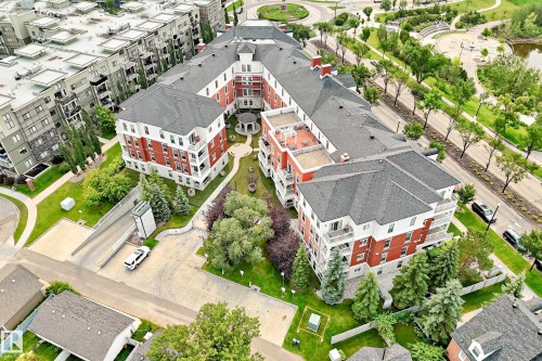 Multi-story building featuring red brick and white siding facade with multiple balconies - #307 1003 Gault Bv Nw, Edmonton, AB - Outdoor With View