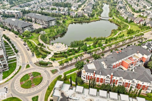 Aerial depiction of a residential neighborhood featuring a central lake - #307 1003 Gault Bv Nw, Edmonton, AB - Outdoor With Body Of Water With View