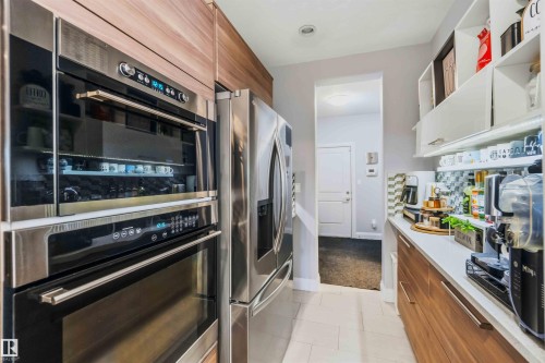 Stainless steel double wall ovens, integrated refrigerator, and wood-finish cabinetry - 7 Etoile Cres, St. Albert, AB 
