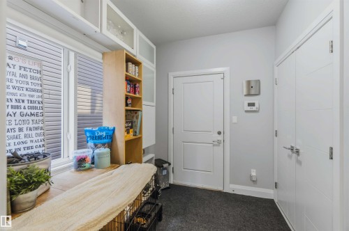 Recessed lighting, window with horizontal blinds, built-in shelving, white cabinetry with frosted glass panels, and multiple white doors with modern hardware - 7 Etoile Cres, St. Albert, AB 
