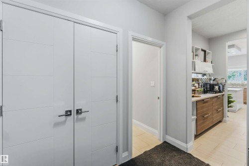 White paneled bi-fold doors with polished hardware, light gray wall paint, and light-toned tile flooring - 7 Etoile Cres, St. Albert, AB 