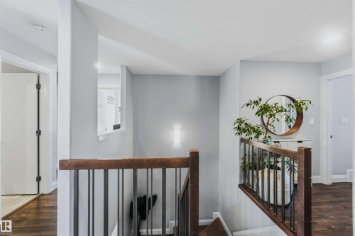 Staircase with wood-finish handrails, black metal balusters, and wood-finish flooring - 7 Etoile Cres, St. Albert, AB 
