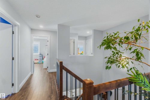 Hallway with wood-finish flooring, recessed lighting, and white paneled doors - 7 Etoile Cres, St. Albert, AB 