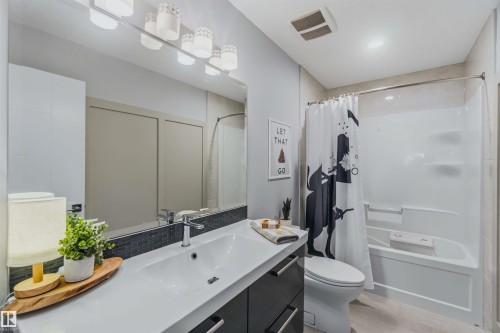 White vanity with integrated sink, chrome faucet, and dark base cabinetry - 7 Etoile Cres, St. Albert, AB 