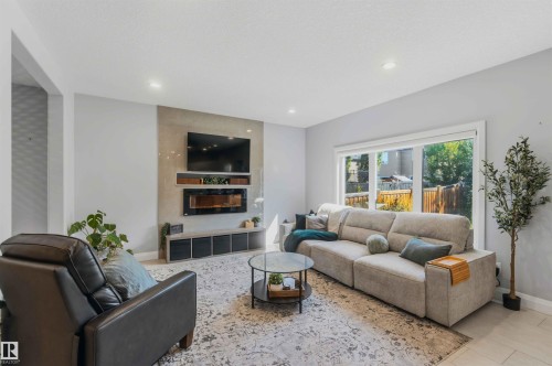 Recessed lighting, large window, tiled flooring, built-in media console, and a wall-mounted electric fireplace - 7 Etoile Cres, St. Albert, AB 