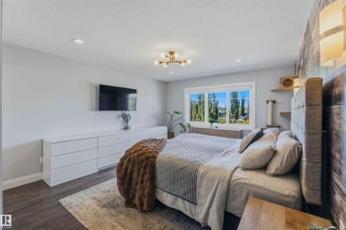 Recessed ceiling lighting, wood-finish flooring, accent wall with sconce lighting, large window, and modern chandelier - 7 Etoile Cres, St. Albert, AB 