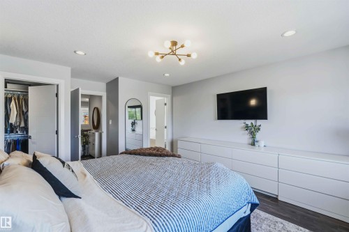 Recessed lighting, contemporary chandelier, wood-finish flooring, white flat-panel doors, and an open closet with built-in shelving - 7 Etoile Cres, St. Albert, AB 