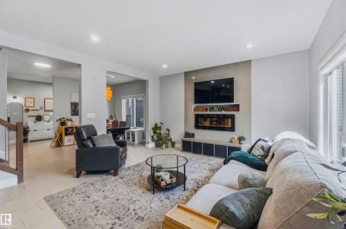 Recessed lighting, light-toned walls, and a built-in electric fireplace with an accent wall - 7 Etoile Cres, St. Albert, AB 