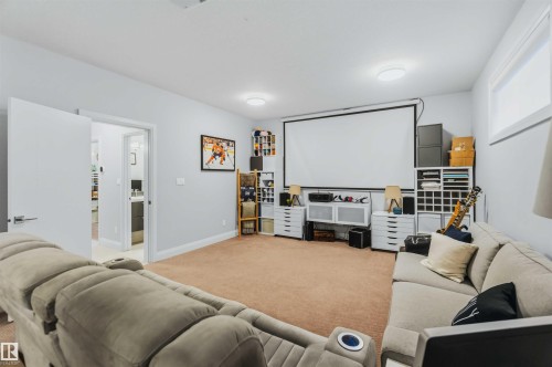 Recessed lighting, light gray wall color, light brown carpeting, interior doors with modern hardware, and a wall-mounted projection screen - 7 Etoile Cres, St. Albert, AB 