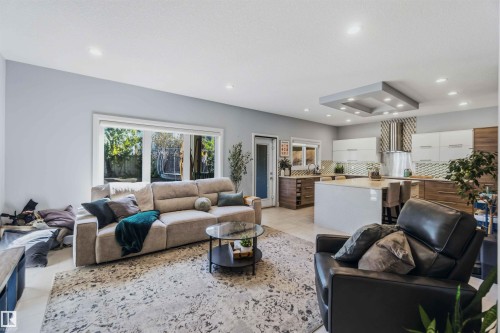 Open-concept living area with large window, recessed lighting, and a kitchen island with seating - 7 Etoile Cres, St. Albert, AB 