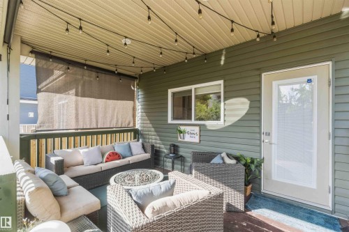 Covered porch with wood-finish decking, horizontal siding, and a white framed window - 7 Etoile Cres, St. Albert, AB 