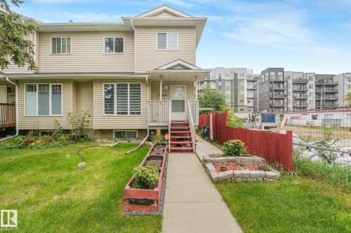 Two-story residence featuring light-toned siding, a front porch with railing, and a concrete walkway - 12843 67 Street Nw, Edmonton, AB 