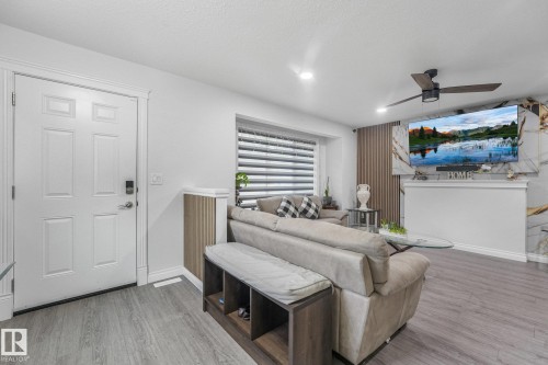 Recessed lighting, wood-finish flooring, white paneled entry door, window with blinds, and built-in ceiling fan with light - 12843 67 Street Nw, Edmonton, AB 