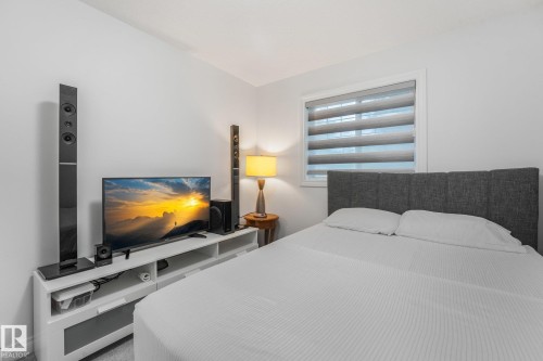 Neutral wall paint, built-in window with horizontal blinds, and a built-in media console with open shelving - 12843 67 Street Nw, Edmonton, AB 
