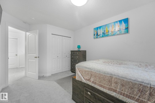 White walls, light-colored carpeting, and a built-in closet with bi-fold doors - 12843 67 Street Nw, Edmonton, AB 