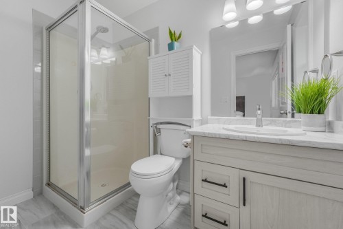 Glass-enclosed shower with a chrome shower head and tiled surround - 12843 67 Street Nw, Edmonton, AB 
