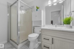 Glass-enclosed shower with a chrome shower head and tiled surround - 