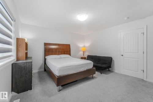 Neutral wall color, carpeted flooring, window with horizontal blinds, overhead flush mount lighting, and a paneled door with an arched top - 12843 67 Street Nw, Edmonton, AB 