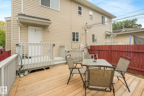Expansive wood deck with a red privacy fence and exterior siding - 12843 67 Street Nw, Edmonton, AB 