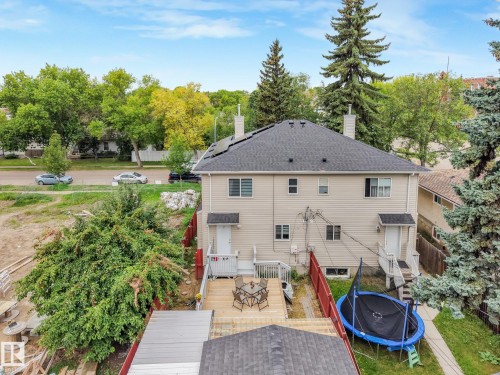 Split-level property featuring a multi-tier deck, beige siding, and a dark shingle roof - 12843 67 Street Nw, Edmonton, AB 