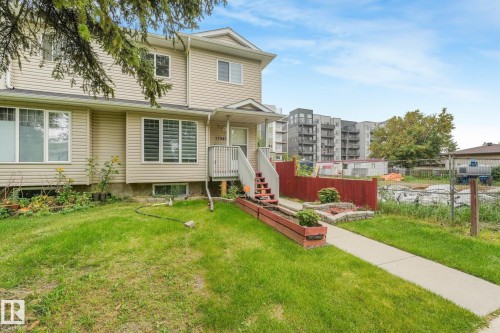 Tan siding exterior with a covered porch and white trim windows - 12843 67 Street Nw, Edmonton, AB 