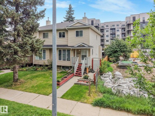 Two-story exterior with light-colored siding, a pitched roof, and a front entry with red-painted stairs - 12843 67 Street Nw, Edmonton, AB 