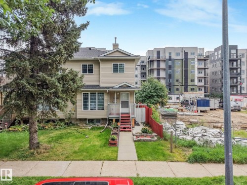 Siding exterior with multiple windows, front porch with railings, and a concrete walkway - 12843 67 Street Nw, Edmonton, AB 