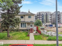 Siding exterior with multiple windows, front porch with railings, and a concrete walkway - 