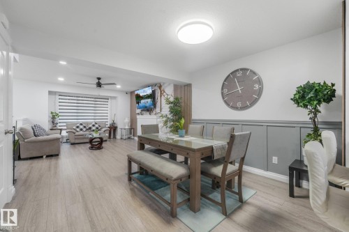 Light wood-finish flooring extends throughout, complemented by recessed lighting and a ceiling fan - 12843 67 Street Nw, Edmonton, AB 