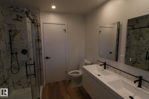 Dual vanity with integrated sinks, matte black fixtures, and framed backlit mirrors - 4224 110 Street Nw, Edmonton, AB 