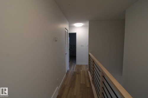 Wood-finish flooring, contemporary railing with horizontal bars, recessed ceiling light, and light-toned wall finishes - 4224 110 Street Nw, Edmonton, AB 