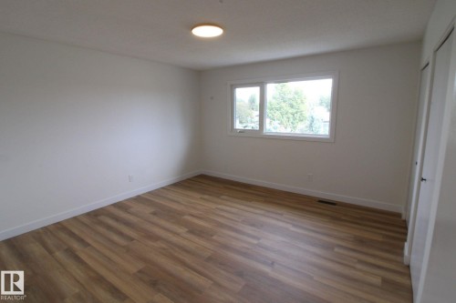 Warm wood-finish flooring with crisp white walls - 4224 110 Street Nw, Edmonton, AB 