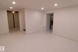 Recessed ceiling lighting, light-toned flooring, white painted walls, and open doorways - 