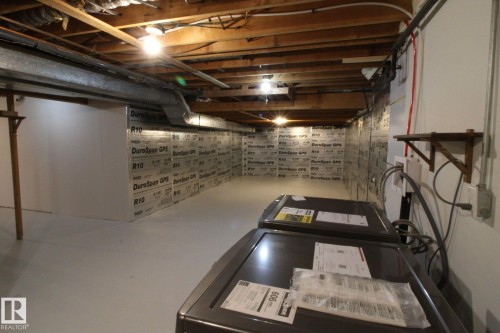 Unfinished basement area featuring exposed ceiling joists, insulated walls, and a concrete floor - 4224 110 Street Nw, Edmonton, AB 