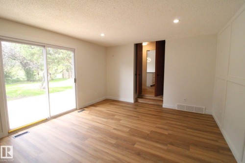Wood-finish flooring, sliding glass doors, recessed lighting, and white walls - 4224 110 Street Nw, Edmonton, AB 