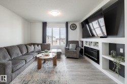 Recessed shelving with an electric fireplace, wood-finish flooring, and white walls - 