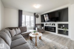 Wood-finish flooring, built-in entertainment center, electric fireplace, built-in shelving, and large window - 