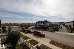Neighborhood streetscape featuring paved roads, sidewalks, and a white picket fence - 