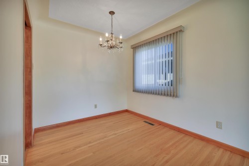 Hardwood flooring, chandelier lighting, window with vertical blinds, and light-toned walls - 13416 102 Street Nw, Edmonton, AB 