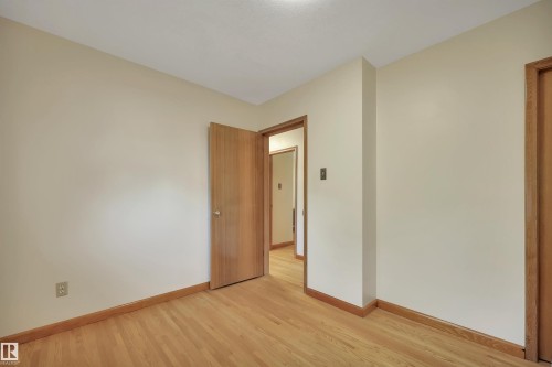 Light-toned walls with wood-finish flooring and trim - 13416 102 Street Nw, Edmonton, AB 