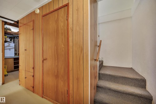Wood-paneled wall with integrated cabinetry and a wood-finish door - 13416 102 Street Nw, Edmonton, AB 