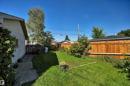 Manicured lawn area with a solid wood fence and mature trees - 13416 102 Street Nw, Edmonton, AB 