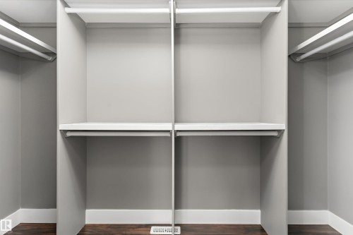 Built-in closet system featuring multiple shelving units, hanging rods, and wood-finish flooring - 17535 110 Street Nw, Edmonton, AB 