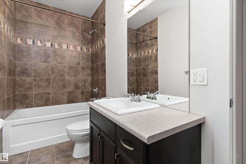 Brown tile flooring and shower surround with an accent tile band - 17535 110 Street Nw, Edmonton, AB 