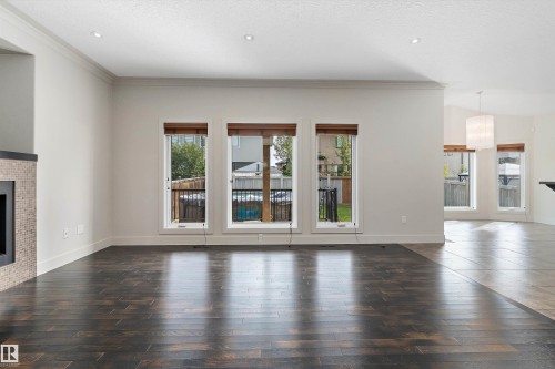 Dark wood-finish flooring, recessed lighting, and a fireplace with a mosaic tile surround - 17535 110 Street Nw, Edmonton, AB 