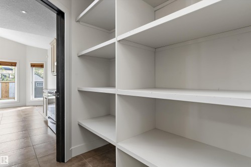 Custom built-in white shelving, recessed lighting, vaulted ceiling, and tan tile flooring - 17535 110 Street Nw, Edmonton, AB 