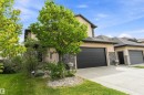 Stucco exterior with stone accents, attached two-car garage, concrete driveway, and established front landscaping - 17535 110 Street Nw, Edmonton, AB 